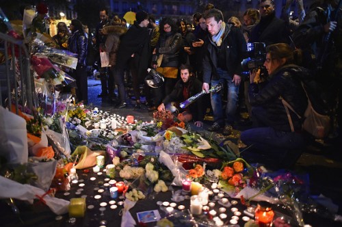PARIS, FRANCE - NOVEMBER 14:  People place flowers and candles on the pavement near the scene of yesterday's Bataclan Theatre terrorist attack on November 14, 2015 in Paris, France. At least 120 people have been killed and over 200 injured, 80 of which seriously, following a series of terrorist attacks in the French capital.  (Photo by Jeff J Mitchell/Getty Images)
